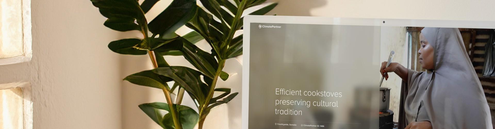 Mehr Transparenz zu Klimaschutzprojekten: ClimatePartner präsentiert neues Produktangebot Bildschirm auf einem Schreibtisch neben einer Pflanze